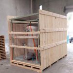 Wooden Shipping Case with oversized machine inside wooden shipping case with image of Crate n Pack Solutions is background.