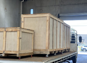 plywood boxes on truck with crate n pack solutions logo in background