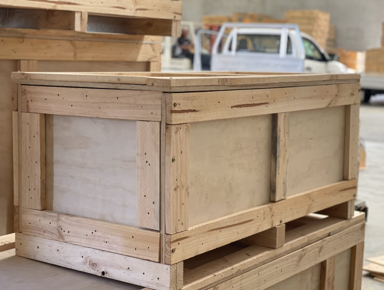 plywood boxes on truck with crate n pack solutions logo in background