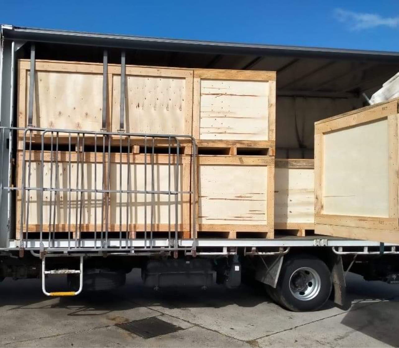 plywood boxes on truck with crate n pack solutions logo in background