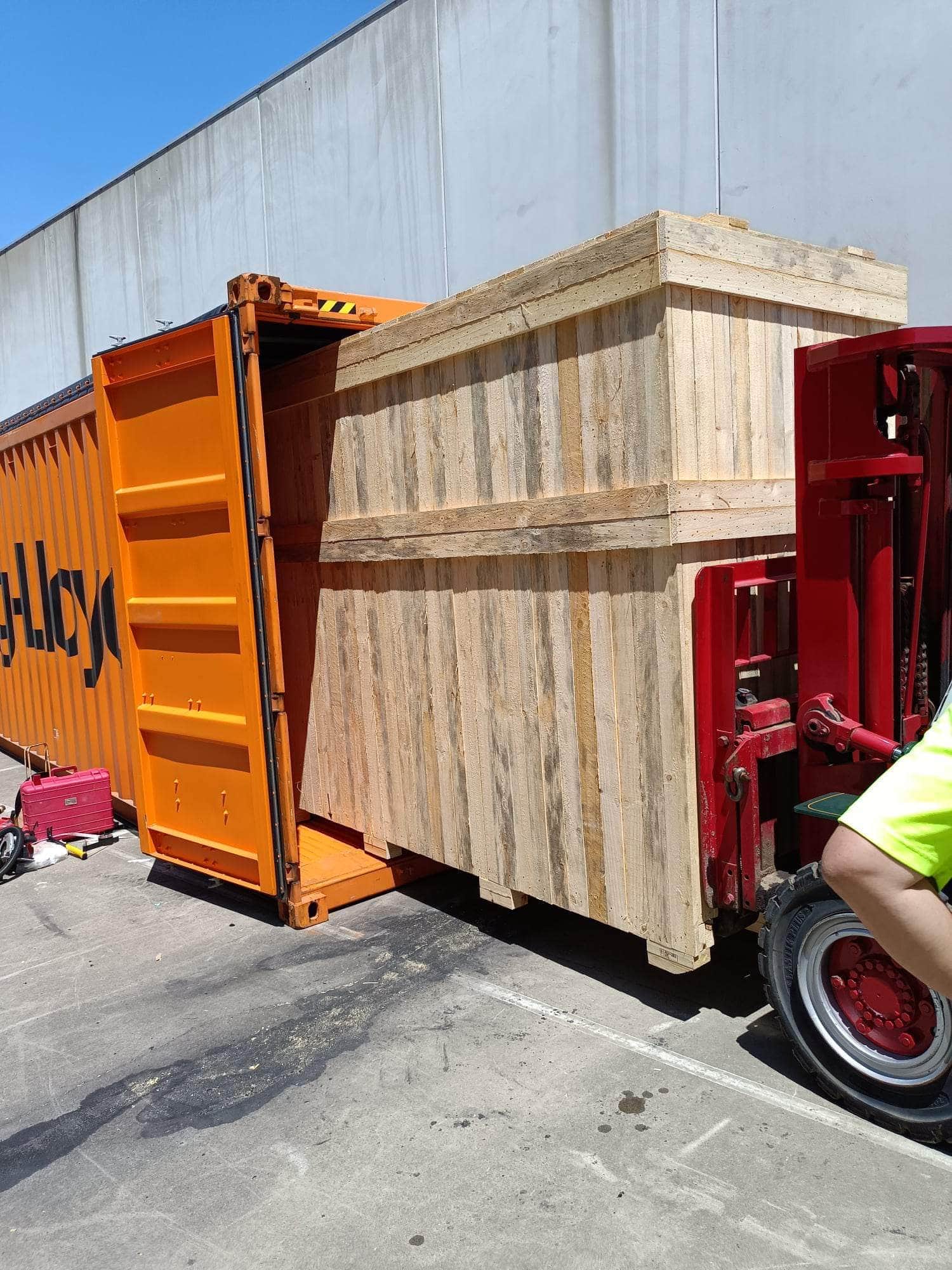 wooden crate being loaded into shipping container