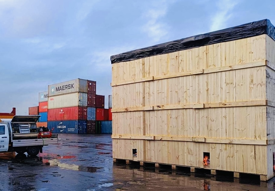 wooden shipping crate and shipping containers in background