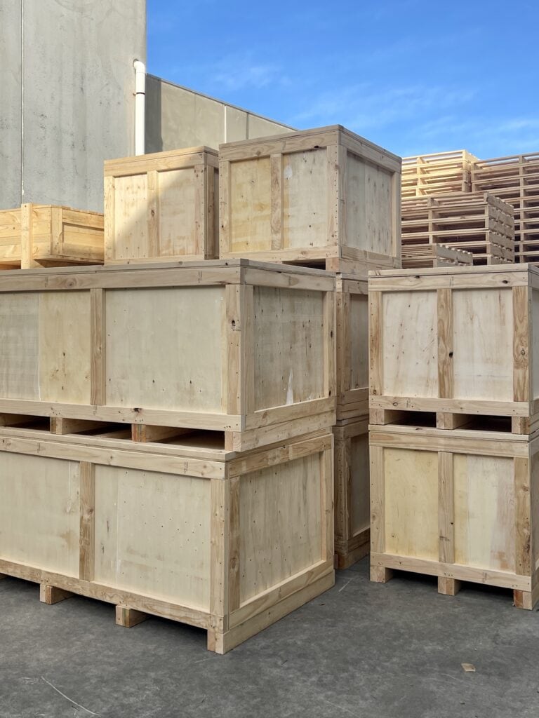 wooden plywood boxes and timber pallets in background.