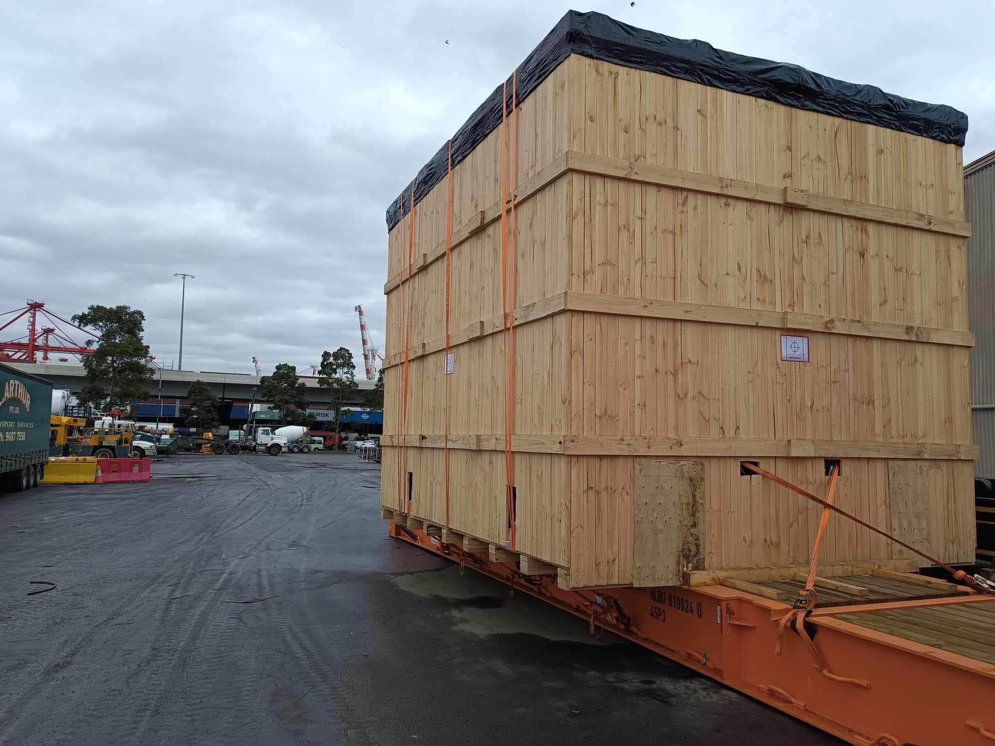 timber shipping case on top of flat racked shipping container