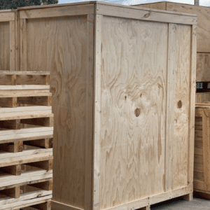 large plywood box and wooden pallets stacked in background