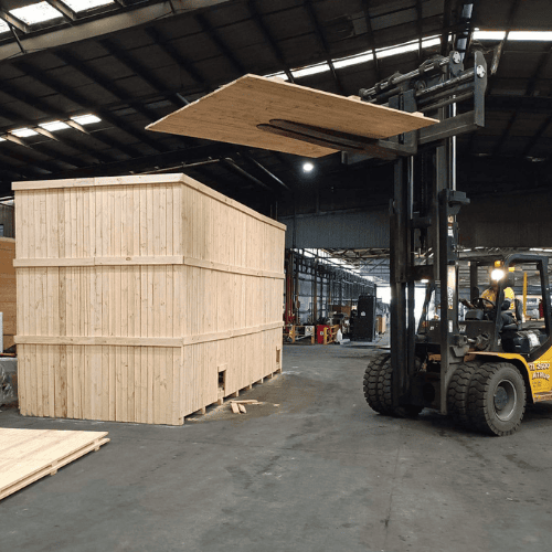 wooden shipping crate and forklift with crate n pack solutions logo in background