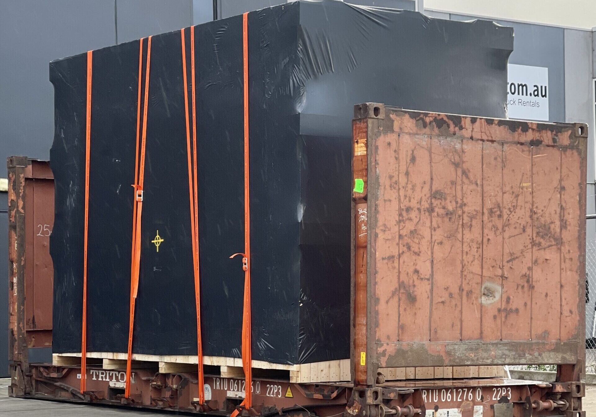 shipping container and black shrink wrapped machine