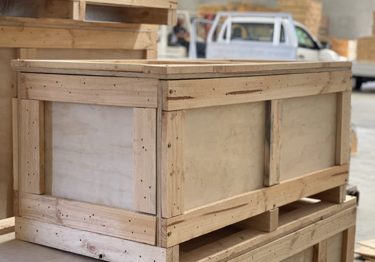 plywood boxes on truck with crate n pack solutions logo in background