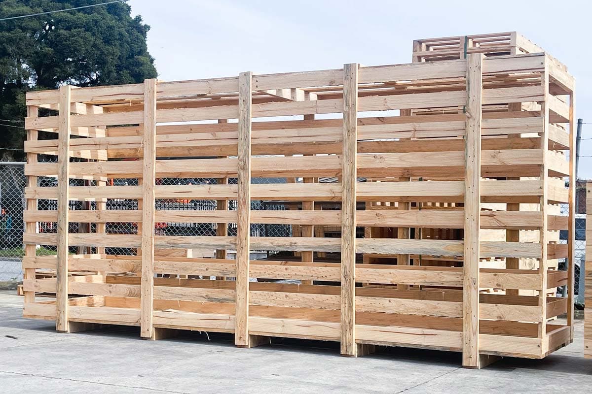 large wooden shipping crate with pallets stacked in background